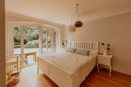 una camera con letto, tavolo e finestra di Landhaus Kurzenmoor - FeWo Sommerhaus, 100 qm 