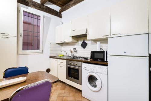 uma cozinha com uma máquina de lavar e secar roupa e uma mesa em Cozy central apartment by Wonderful Italy em Bolonha