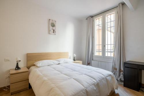ein weißes Schlafzimmer mit einem großen Bett und einem Fenster in der Unterkunft Cozy central apartment by Wonderful Italy in Bologna