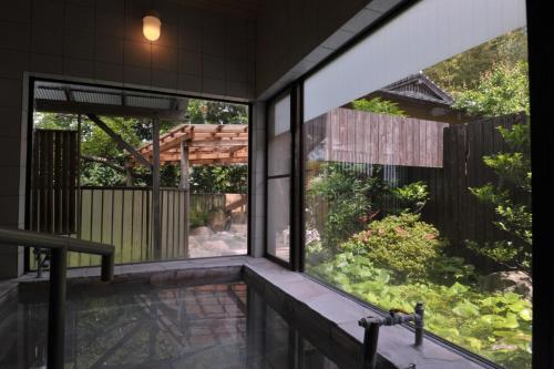 a house with a view of a garden from a balcony at Tomomi Sanso / Vacation STAY 3832 in Yufuin