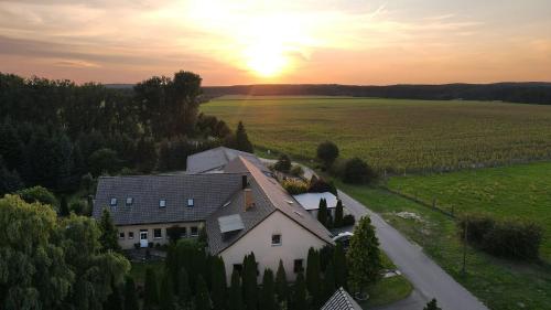 a house in a field with the sunset in the background at Gästehaus Best End in Bülstringen