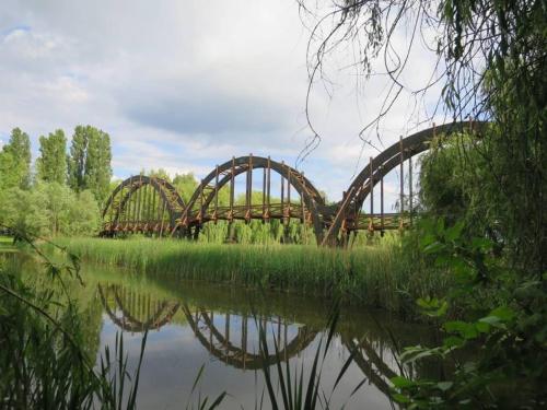 a bridge over a river with its reflection in the water at Golden Ball apartman magánszálláshely in Zalakaros