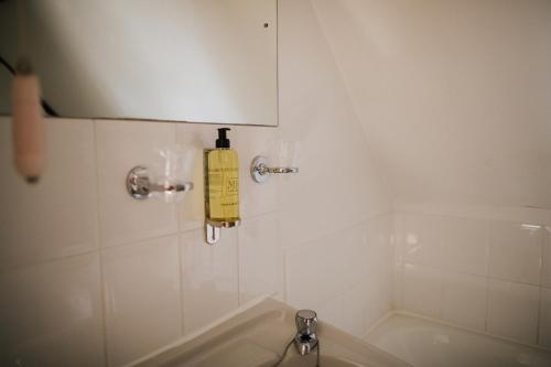 a bathroom with a yellow fire extinguisher on the wall at The Stratton House Hotel in Biggleswade