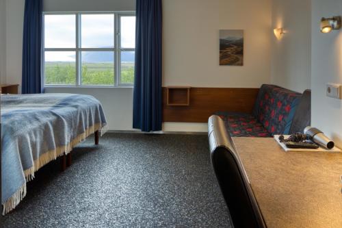 a hotel room with a bed and a couch at Brunnholl Country Guesthouse in Höfn