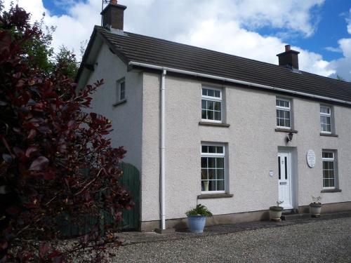 a white house with a black roof at Lisnafillan Lodge in Ballymena