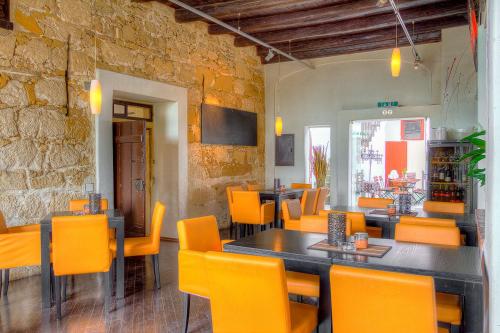un restaurante con mesas y sillas naranjas en una habitación en unser rosa Haus für Sie en Rust