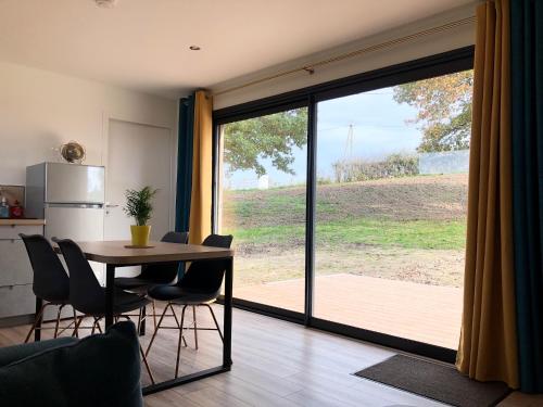 a kitchen and dining room with a table and a large window at Le Banc Bourguignon in Saint-Leu