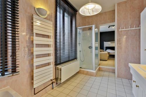 een badkamer met een inloopdouche en een wastafel bij Maison Lambic in De Panne
