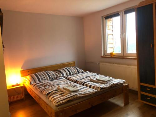 1 dormitorio con 1 cama con lámpara y ventana en Guest House u chalupky, en Jablunkov