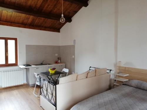 a white bedroom with a bed and a kitchen at Elisa affittacamere in Foligno
