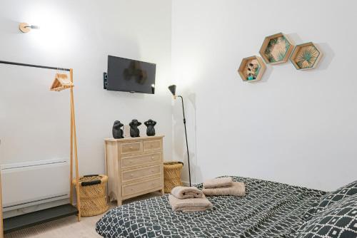 a bedroom with a bed and a tv on the wall at Vence... un goût d'ailleurs in Vence