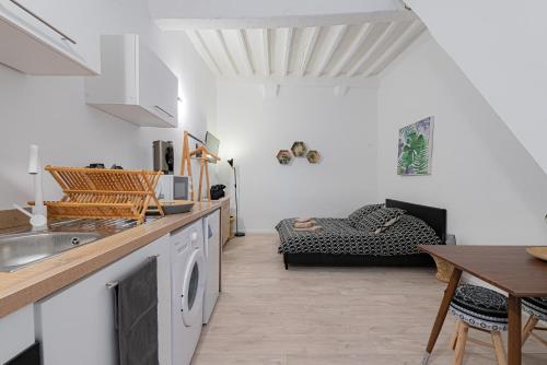 a kitchen and living room with a table and a couch at Vence... un goût d'ailleurs in Vence