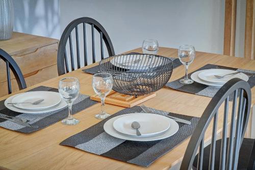 une table en bois avec des assiettes et des verres à vin dessus dans l'établissement IMMOGROOM- Renovated- Large terrace- AC- Shops- Parking, à Cannes
