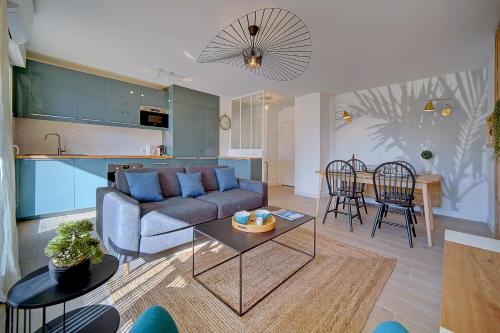 ein Wohnzimmer und eine Küche mit einem Sofa und einem Tisch in der Unterkunft IMMOGROOM- Renovated- Large terrace- AC- Shops- Parking in Cannes