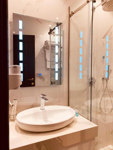 a bathroom with a sink and a shower at Hotel Kloest in Durrës
