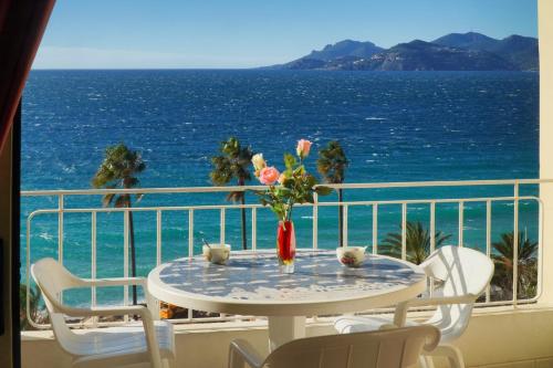 uma mesa numa varanda com vista para o oceano em IMMOGROOM- Sea view - Center- AC- Front of the beaches em Cannes