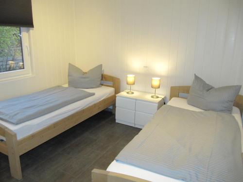 Dos camas en una habitación con dos lámparas. en Erlengrund 20, en Isenbüttel