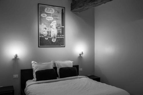 een slaapkamer met een bed en een foto aan de muur bij B&B L'Epicurie in Hoegaarden