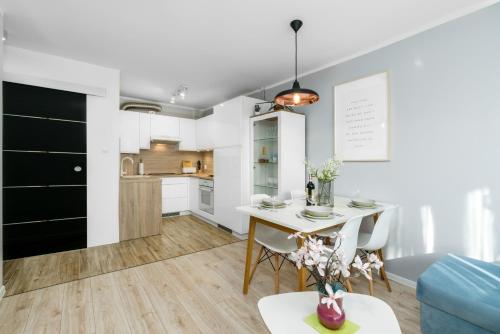 uma cozinha e sala de estar com mesa e cadeiras em Apartment Poznan Park Cytadela by Renters em Poznań