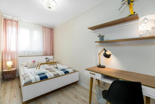 um pequeno quarto com uma cama e uma secretária em Apartment Poznan Park Cytadela by Renters em Poznań