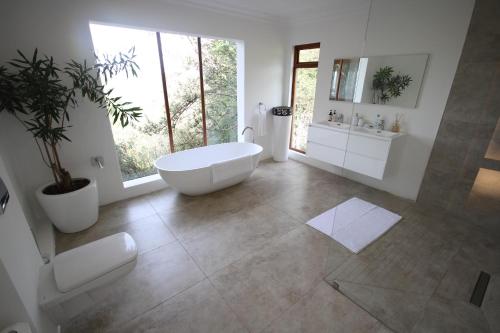 een badkamer met een bad, een wastafel en een toilet bij Crestwood Bed & Breakfast in Curryʼs Post
