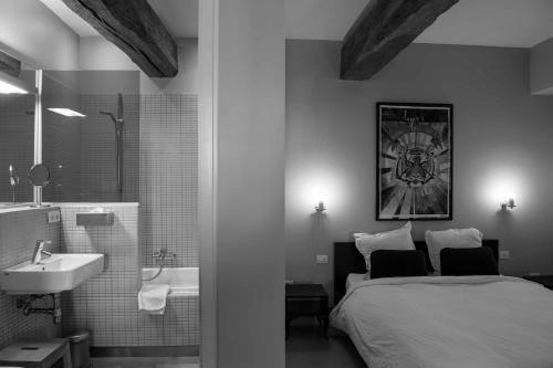 1 dormitorio con 1 cama y baño con lavamanos en B&B L'Epicurie, en Hoegaarden