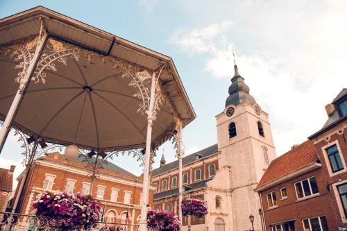 a large building with a clock tower in front of it at B&B L'Epicurie in Hoegaarden