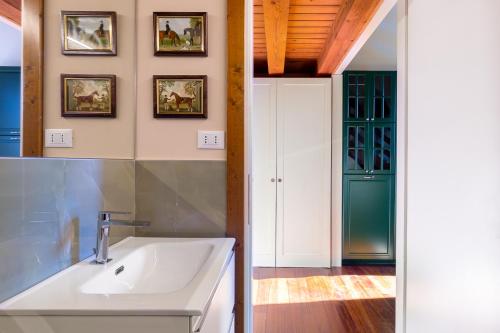 ein Badezimmer mit einem weißen Waschbecken und einer grünen Tür in der Unterkunft Il Vivaio di Villa Grimani Morosini in Martellago