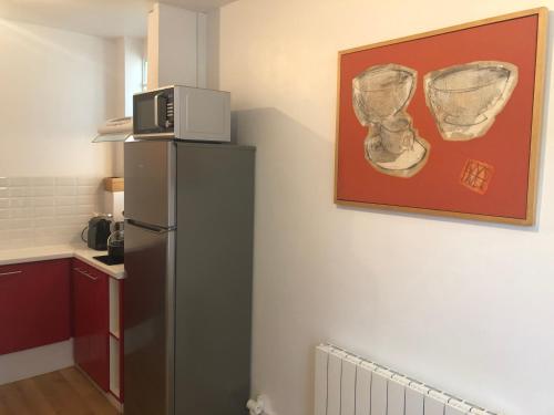 Il comprend une cuisine murale équipée d'un réfrigérateur et d'un four micro-ondes. dans l'établissement Duplex centre ville 200m de la plage, à Dinard