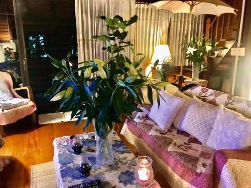 a living room with a vase with a plant on a table at the NOW by Kru Se in Ban Muang Pha
