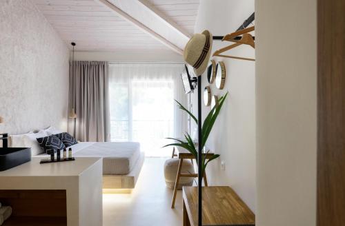 a bedroom with a bed and a table and a desk at Karidi Beach Boutique Suites in Vourvourou