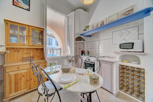 une cuisine avec une table et des chaises dans l'établissement IMMOGROOM - Cosy Apartment - Quiet Place - Provencal style, à Cannes