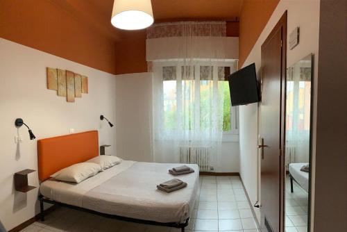 a bedroom with a bed and a television and a bathroom at marconi 22 rooms in Bologna