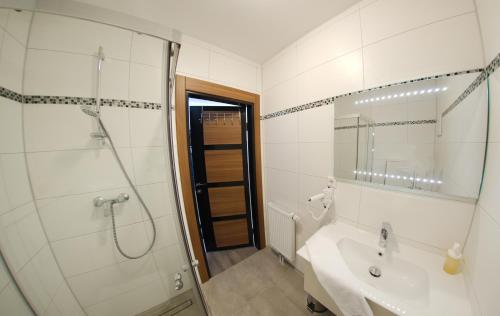 baño blanco con ducha y lavamanos en Hotel Hausen Obertshausen Frankfurt, en Obertshausen
