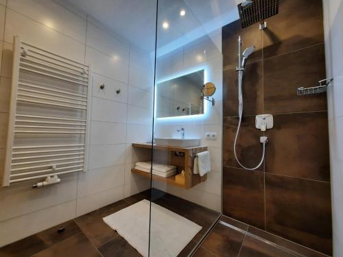 フィルツモースにあるAppartement Hartlのバスルーム(ガラス張りのシャワー、シンク付)