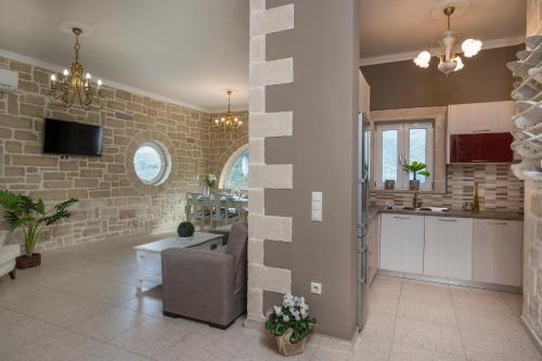 a kitchen and living room with a stone wall at Casa Belvedere Apartments in Kournás