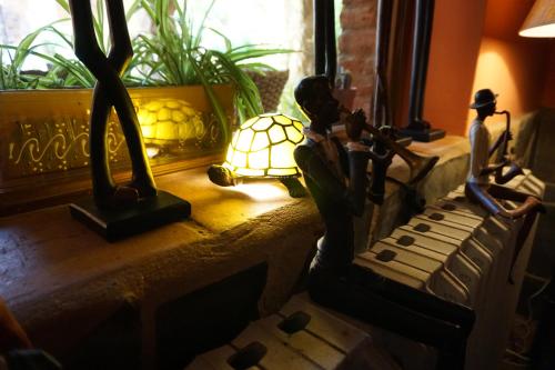 a table with figurines and a lamp next to a window at Hotel Rural Cerro Principe in La Garrovilla