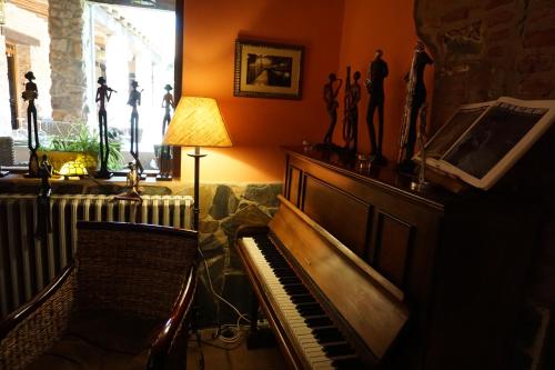 a living room with a piano and a fireplace at Hotel Rural Cerro Principe in La Garrovilla