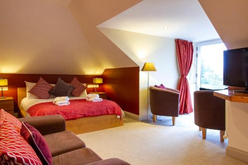 a hotel room with a bed and a tv at The Lookout Keswick in Keswick