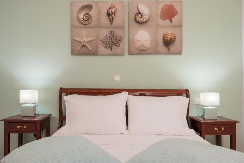 a bedroom with a bed with two tables and two lamps at Casa Belvedere Apartments in Kournás