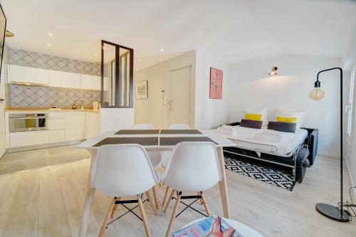 une chambre avec un lit, une table et des chaises dans l'établissement IMMOGROOM - AC - 5min from the beaches 8 min from Palais, à Cannes