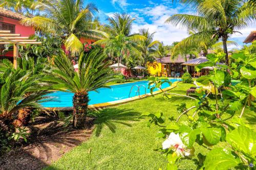 a resort with a swimming pool and palm trees at Pousada Vira Canoa in Itacaré