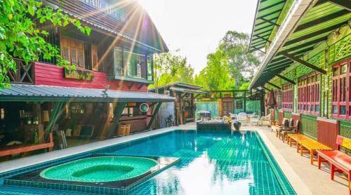 an outdoor swimming pool in a house with a swimming pool at Ban Mai Vintage in Pak Chong