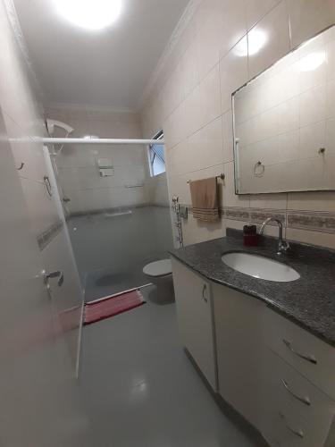 uma casa de banho com um lavatório, um WC e um espelho. em Apto compacto em Floripa-continente em Florianópolis