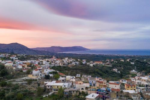 a view of a town with the ocean in the background at Casa Belvedere Apartments in Kournás