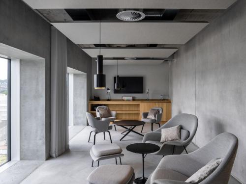 a living room with chairs and a table and a tv at Placid Hotel Design & Lifestyle Zurich in Zürich