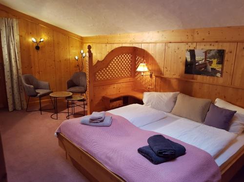 - une chambre avec un grand lit et une couverture violette dans l'établissement Bauernhof Oberscheffau, à Neukirchen am Großvenediger