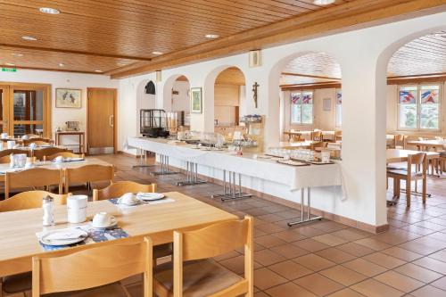 ein Restaurant mit Tischen und Stühlen und einer Theke in der Unterkunft Hotel & Bildungshaus St. Jodern in Visp