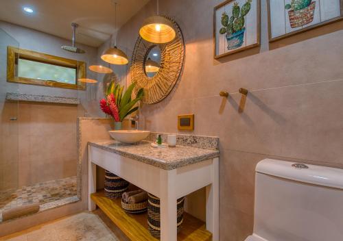 a bathroom with a sink and a shower and a toilet at Hotel Banana Azul - Adults Only in Puerto Viejo