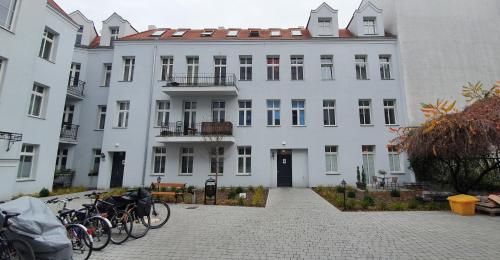 Un edificio blanco con bicicletas estacionadas enfrente. en Apartament Vilda, en Poznan